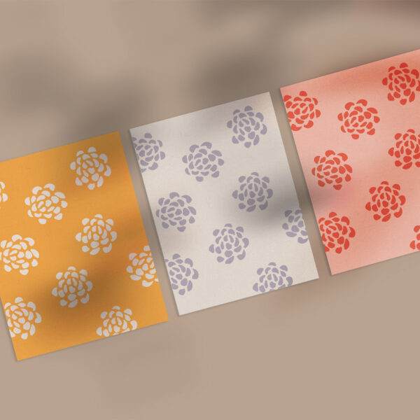 Three different illustrated floral pattern notecards on a brown background with a shadow overlay