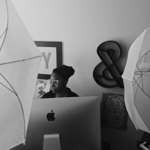 Woman sitting at computer with artwork behind her