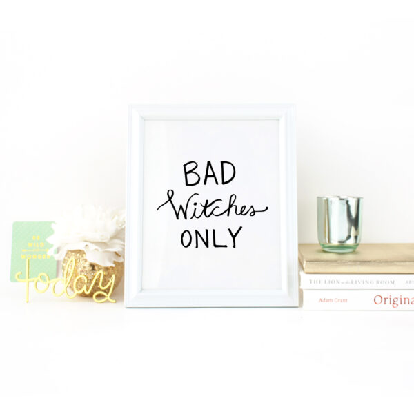 Bad Witches Only handlettered in black on a white background in a white frame on a desk