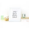 Stay Wild Moon Child Handlettered in black on White Print in a White Frame on a desk