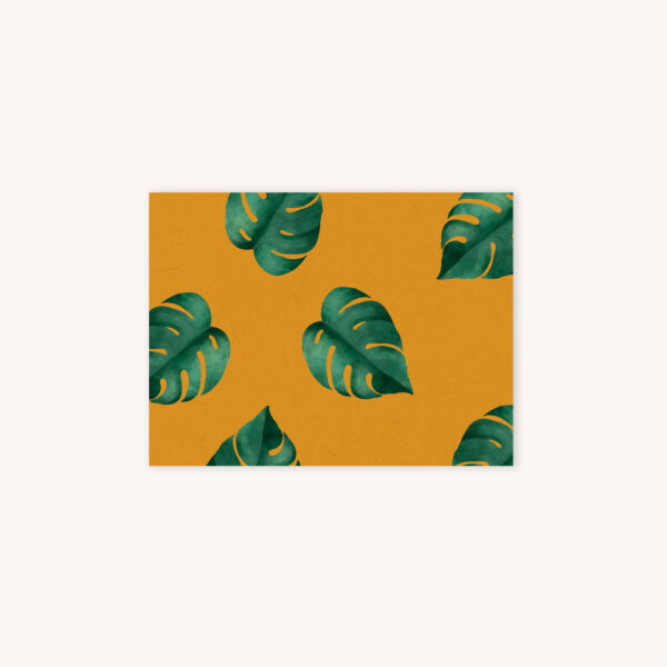 Picture of a mustard yellow notecard with watercolor monstera leaves pattern